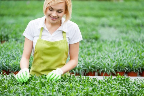 Worker using powered landscaping tools with safety precautions in place